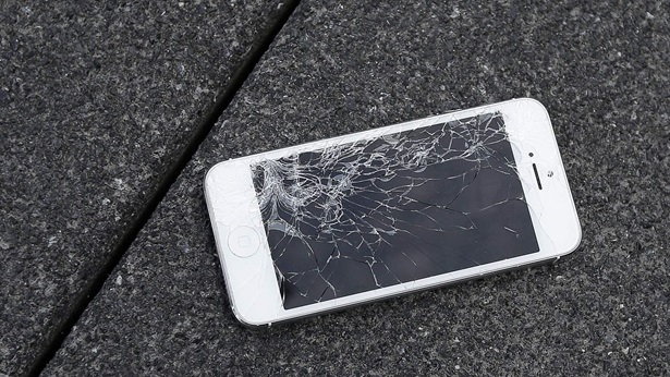 This Aug. 26, 2015, file photo shows an Apple iPhone with a cracked screen after a drop test at the offices of SquareTrade in San Francisco