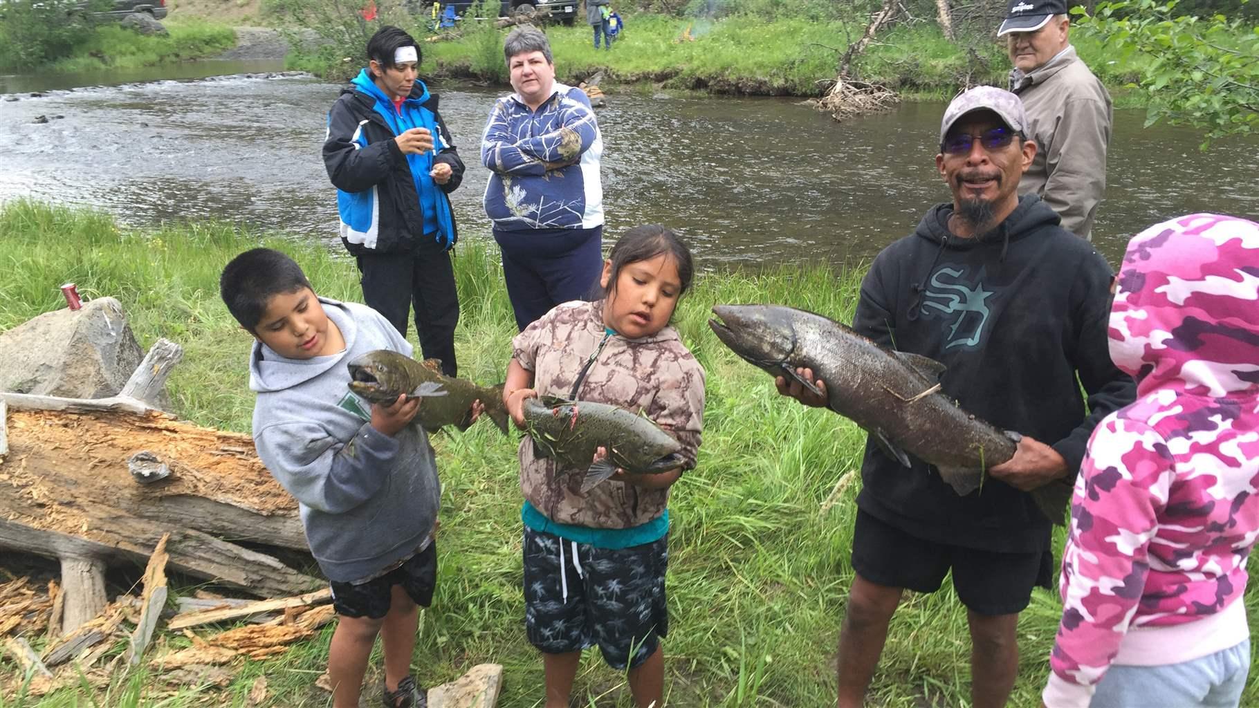 Burns Paiute Tribe holding salmon they are releasing back into the river