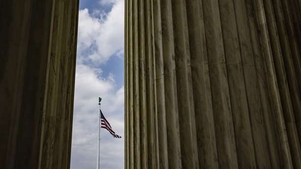 The American flag is seen between the massive columns at the top of the steps to the U.S. Supreme Court on July 24, 2021 in Washington, DC.