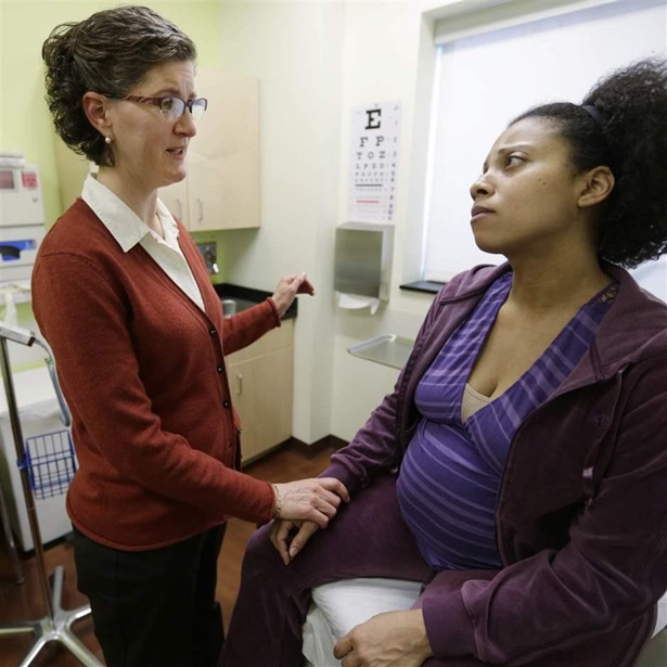 A certified nurse midwife meets with her patient at a birthing center