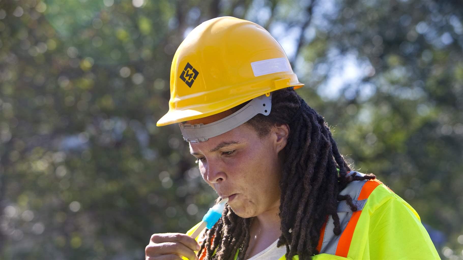 Denni Wimbush cools off with a popsicle on a brief break while working on a road crew on Thursday in the sweltering heat along Wise as it becomes Walnut Avenue in southeast Roanoke.