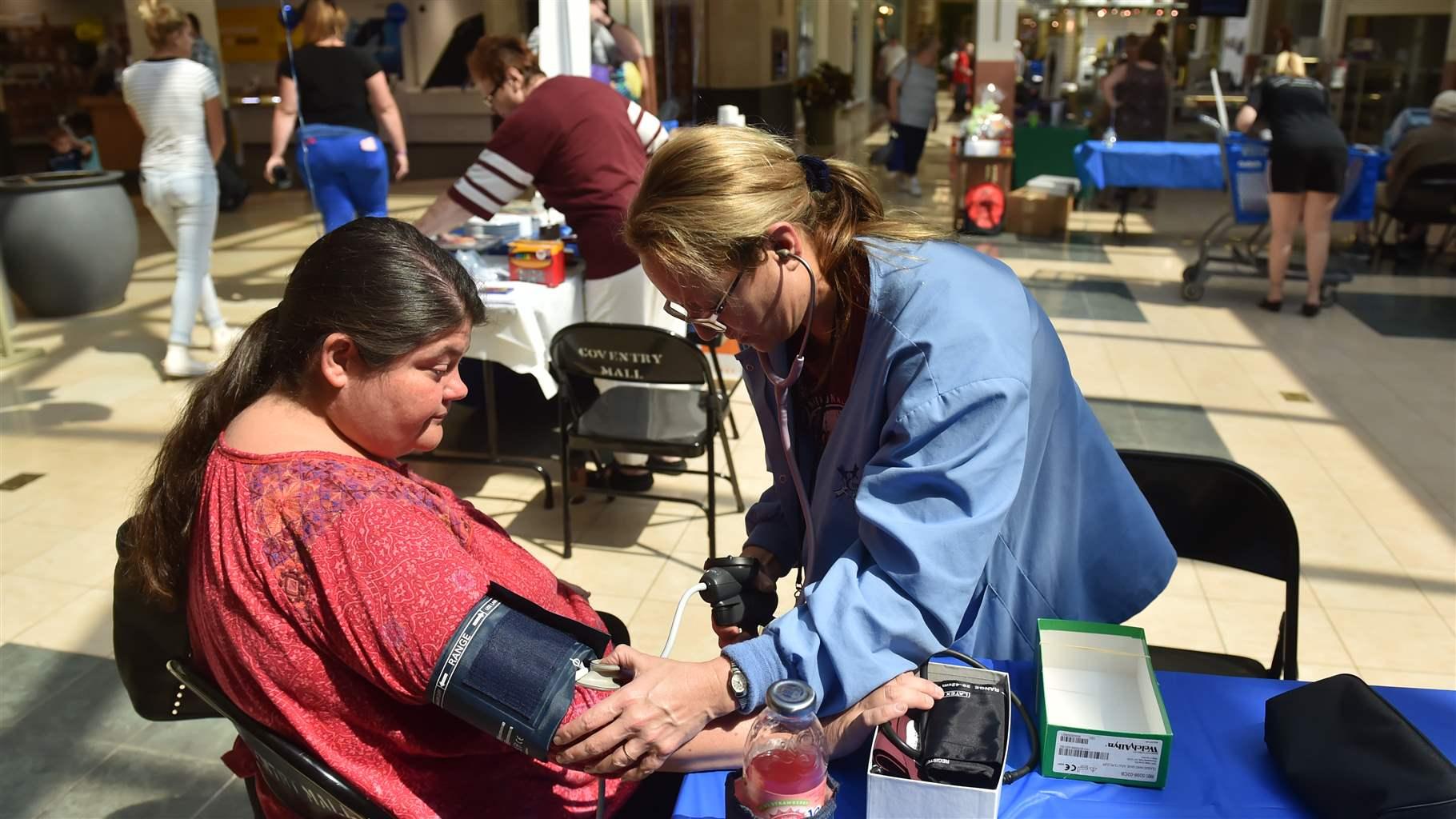 Dori Fostok gets her blood pressure checked by Carol Berube, a Certified Medical Assistant with Community Health and Dental.