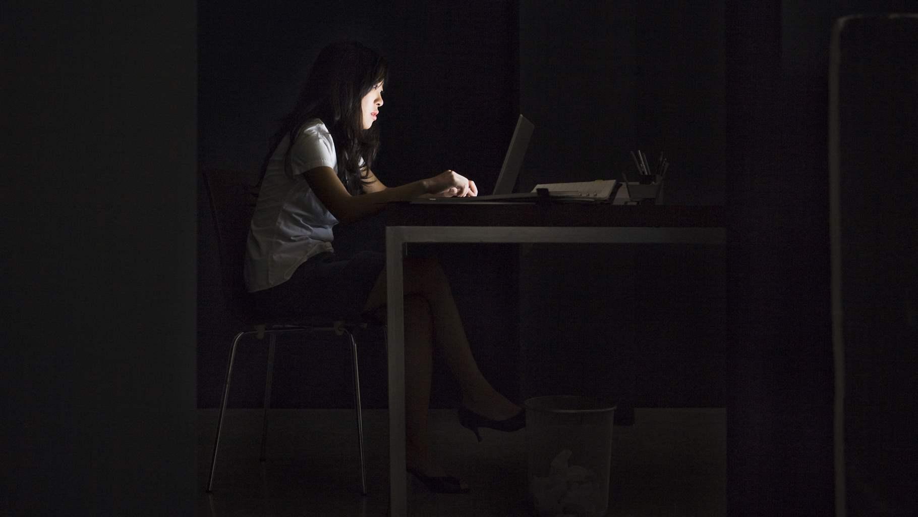 Person at a desk in the dark