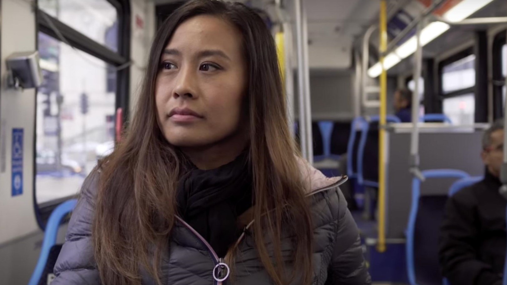 A close up of a woman sitting on a city bus.