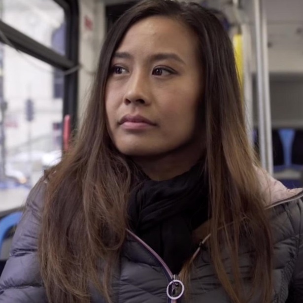A close up of a woman sitting on a city bus.