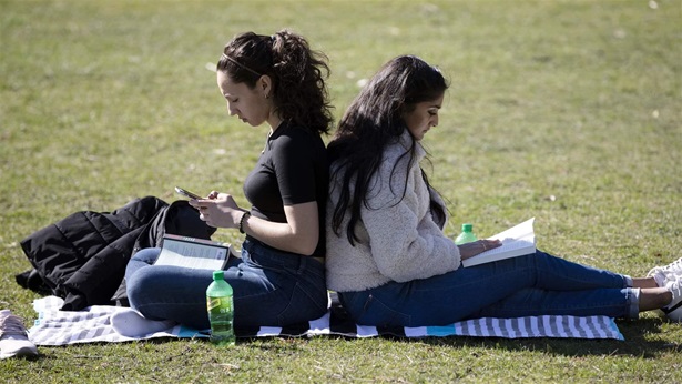 Boston University Dental School students Boston University Dental School students sitting back to back in a field.
