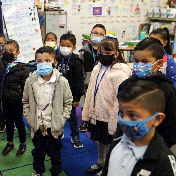 Kindergarteners wear masks while listening to their teacher amid the COVID-19 pandemic at Washington Elementary School Wednesday, Jan. 12, 2022, in Lynwood, Calif. California is making it easier for school districts to hire teachers and other employees amid staffing shortages brought on by the latest surge in coronavirus cases.
