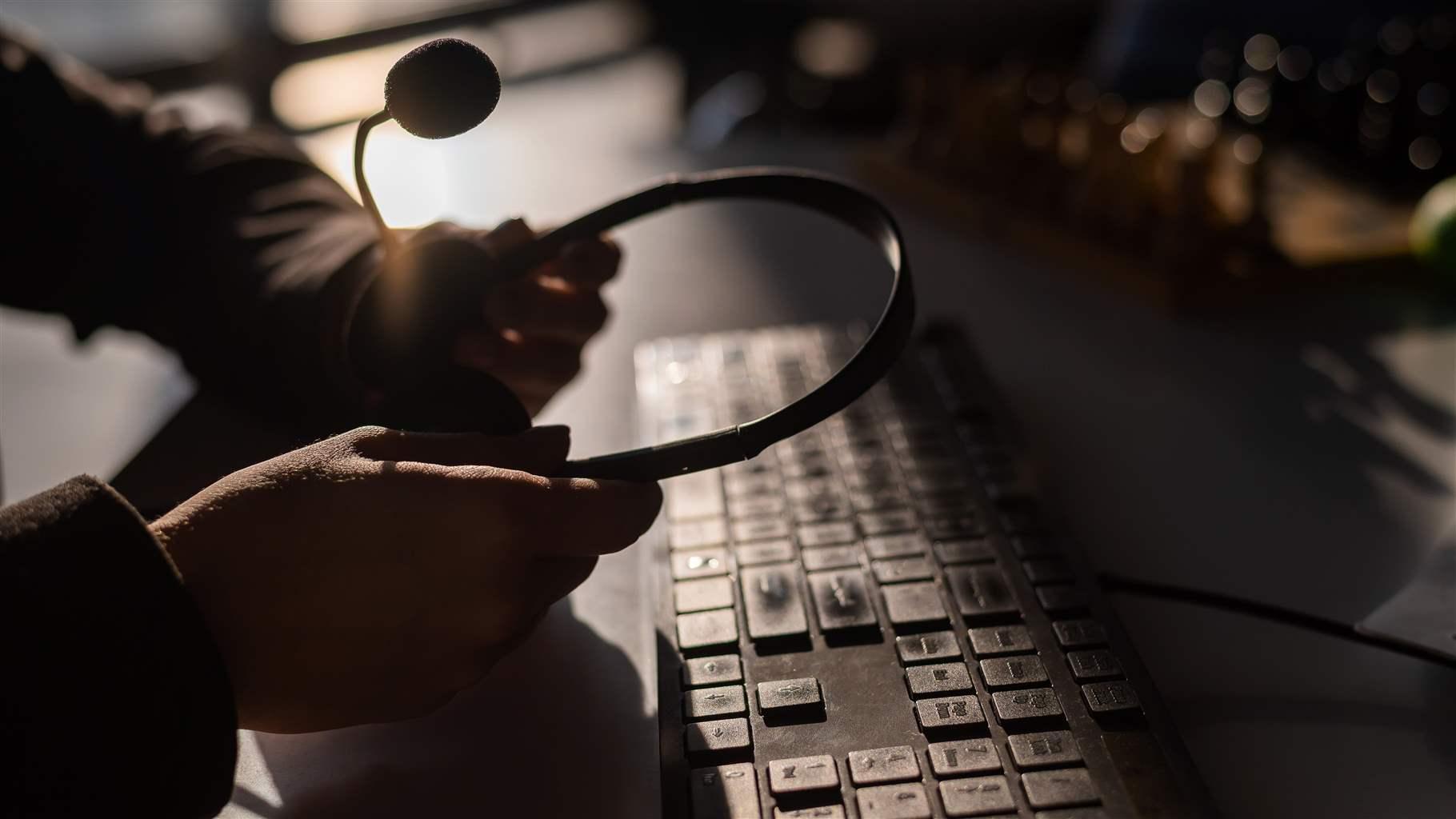 Hands holding headset at desk