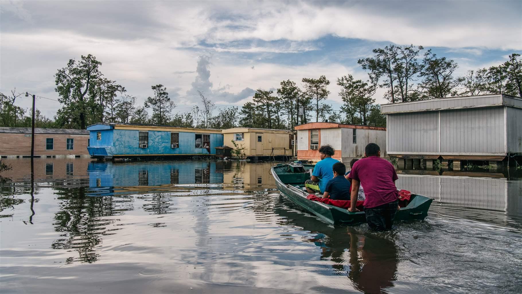 A family in a small boat travel through flooded streets in Barataria, Louisiana.
