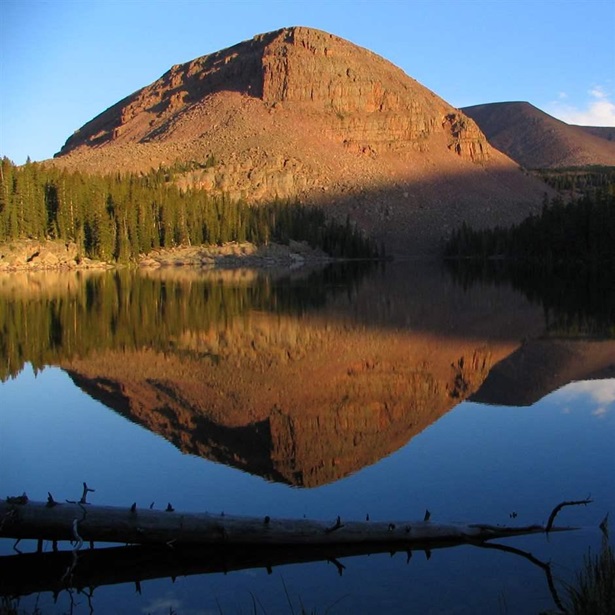 A mountain face reflects off the smooth waters of Point Lake in the West Fork Whiterocks River drainage, just east of the High Uinta Wilderness in the Ashley National Forest