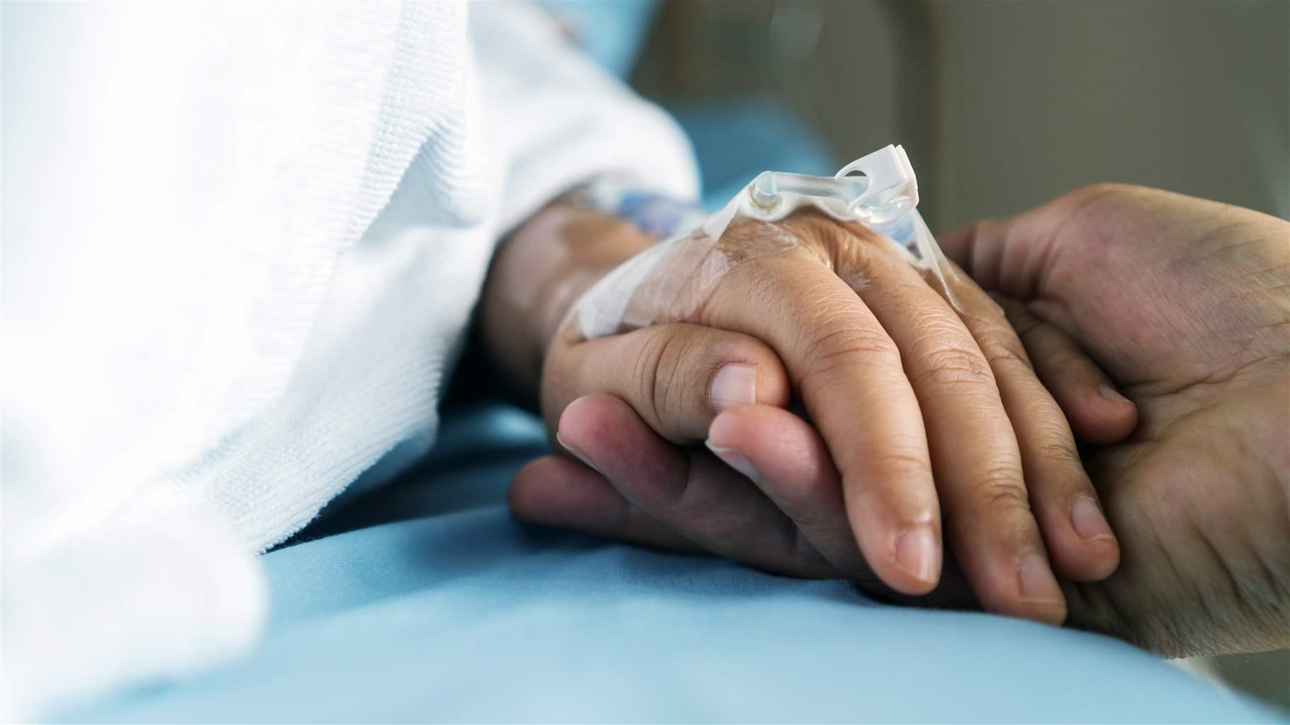 Holding hands in hospital bed
