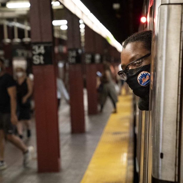 Desmond Hill, a vaccinated MTA conductor, looks out his crew cab window to check the platform for late-arriving passengers as he works the N subway line from Brooklyn's Coney Island to Queen's Astoria-Ditmars neighborhoods, Friday, Aug. 13, 2021, in New York. 