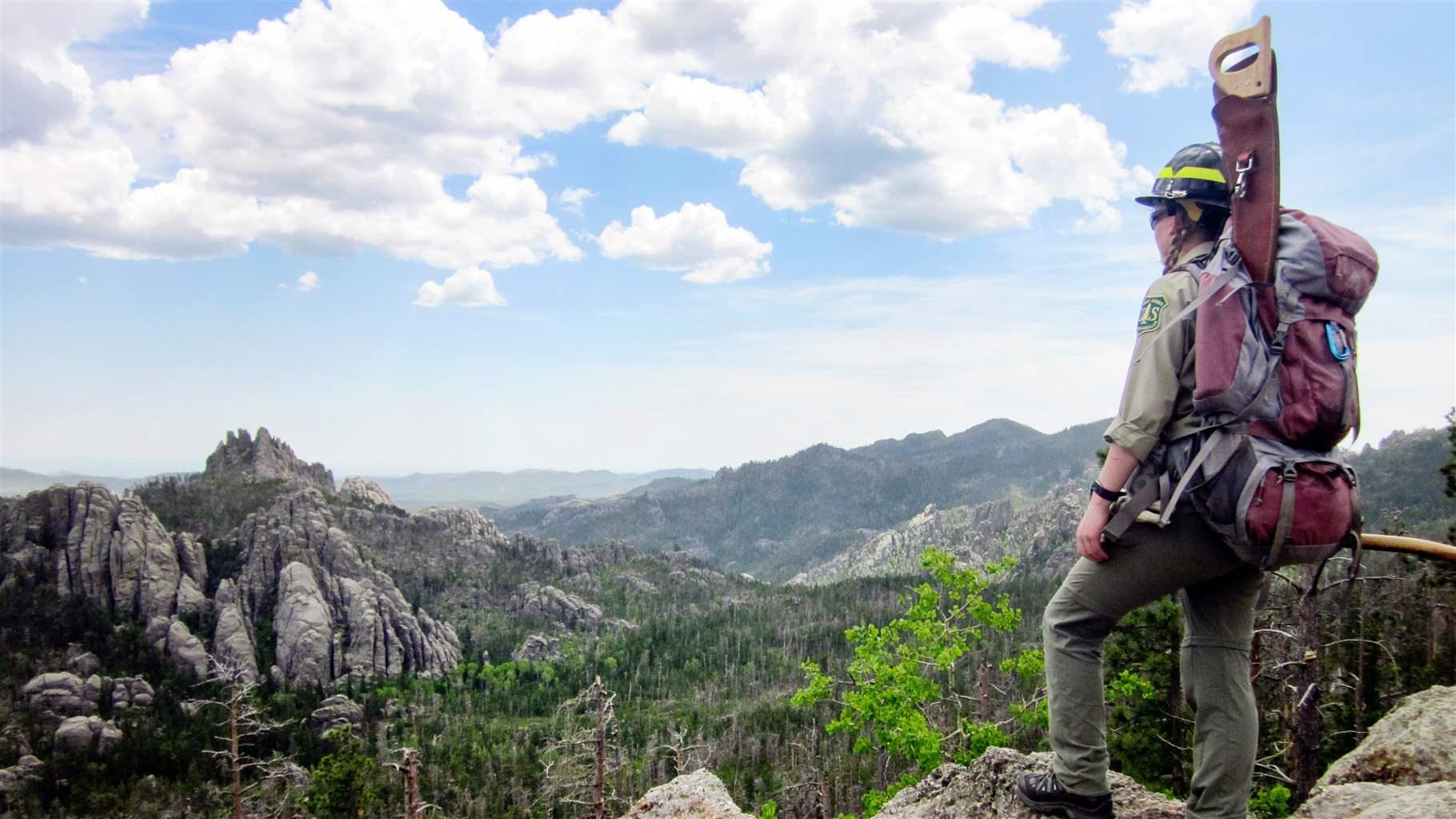 Un empleado del Servicio Forestal se encuentra en lo alto de un mirador en Black Elk Wilderness en Black Hills.