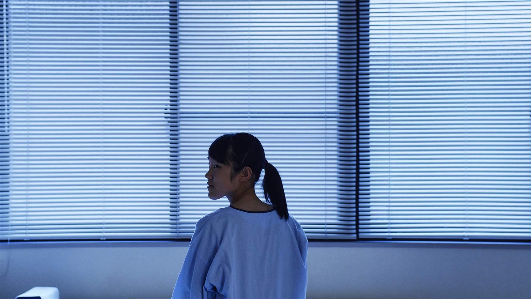 Young female patient sitting in ward bed