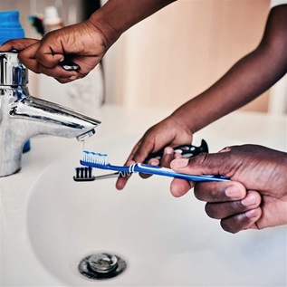 Man and son rinsing toothbrushes