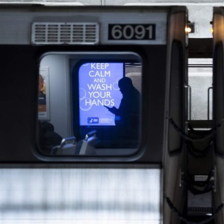 An electronic ad in the from the Centers for Disease Control advises commuters and tourists in the Metro Center subway station in Washington to keep calm and wash your hands on Saturday, March 14, 2020.
