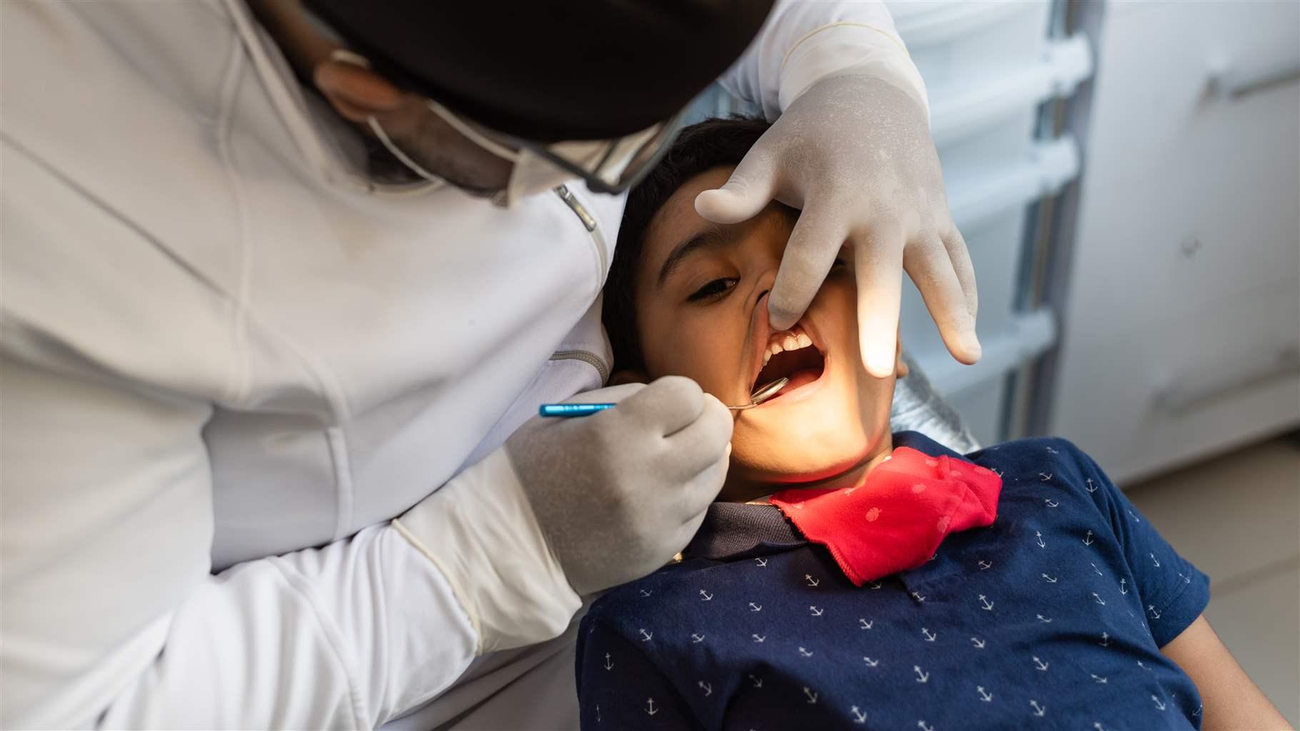 Dentist inspecting child's teeth