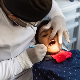 Dentist inspecting child's teeth