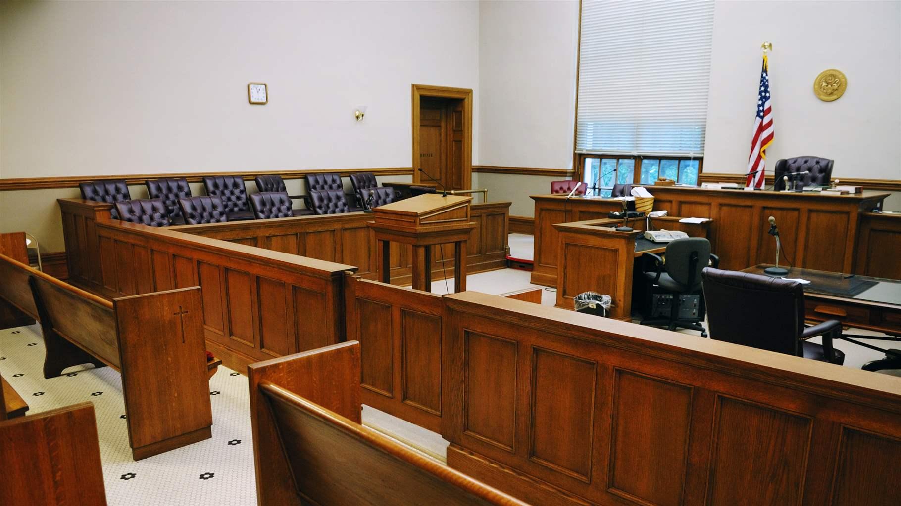A view of an empty courtroom looking toward the judge's bench.  