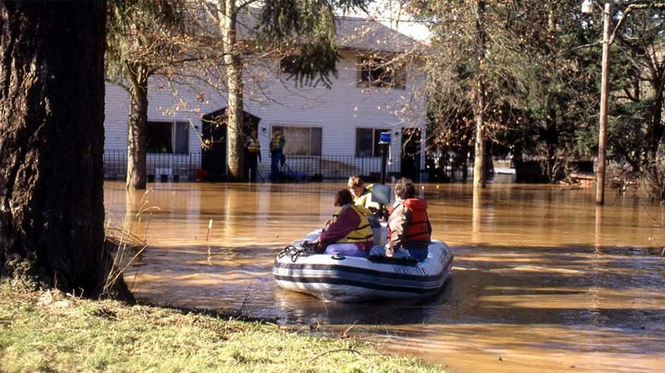 Flood survivors use an inflatable raft in to navigate a flooded residential neighborhood in the Portland area during the Willamette Flood of 1996. 