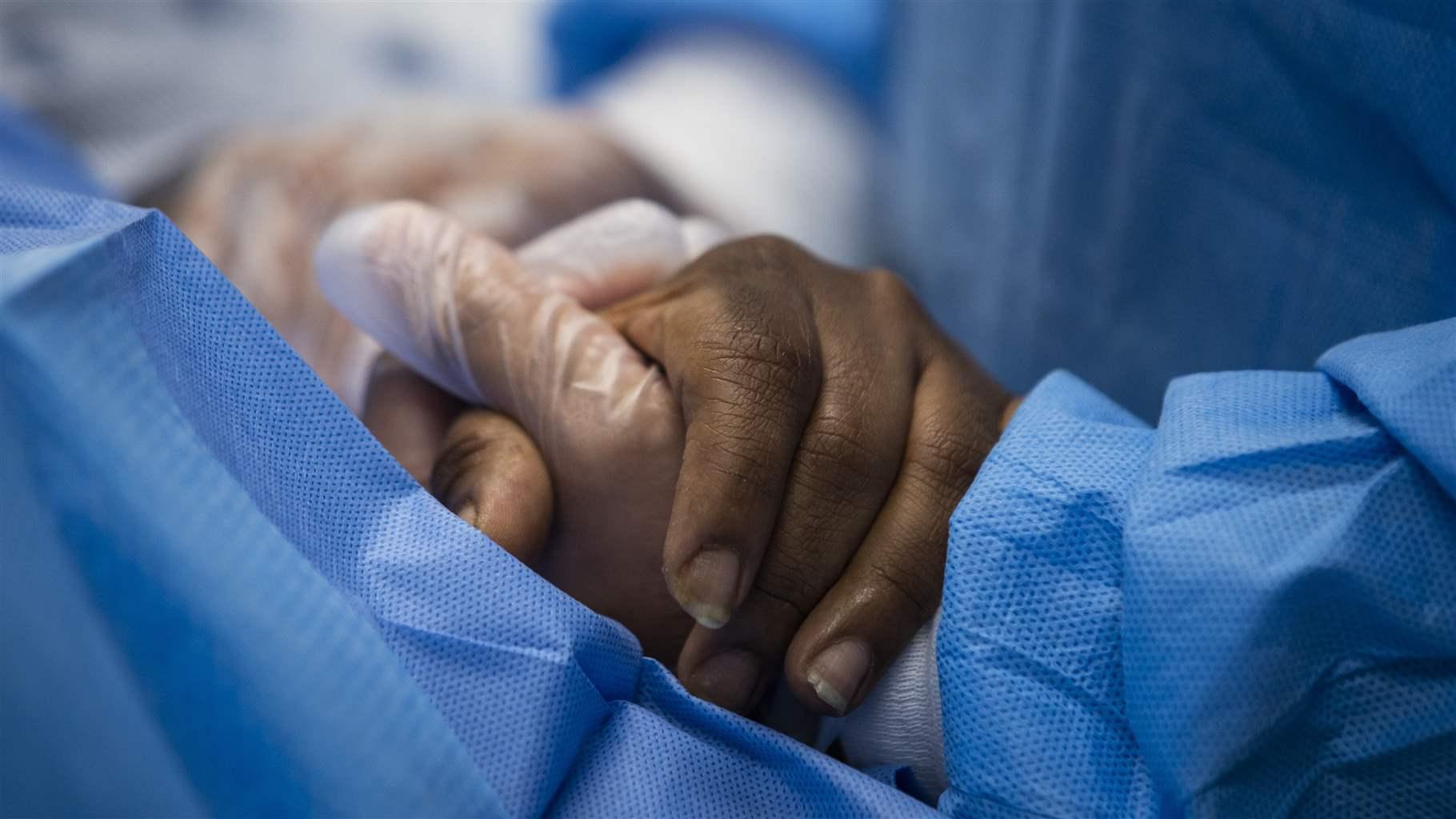 nurse practitioner holds a patient’s hand 