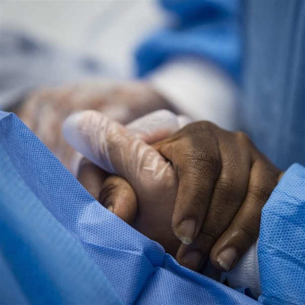 nurse practitioner holds a patient’s hand 