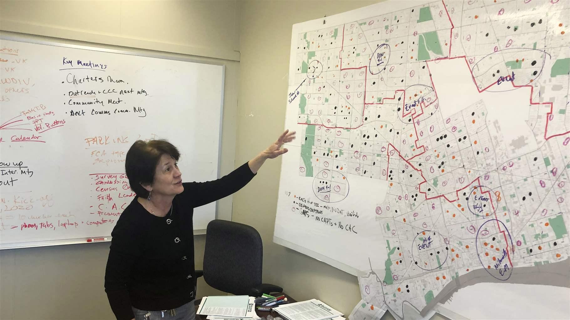 In this Nov. 22, 2019 file photo, Detroit 2020 Census Campaign executive director Victoria Kovari looks over a Detroit map showing city neighborhoods that were under-counted in the 2010 census. 