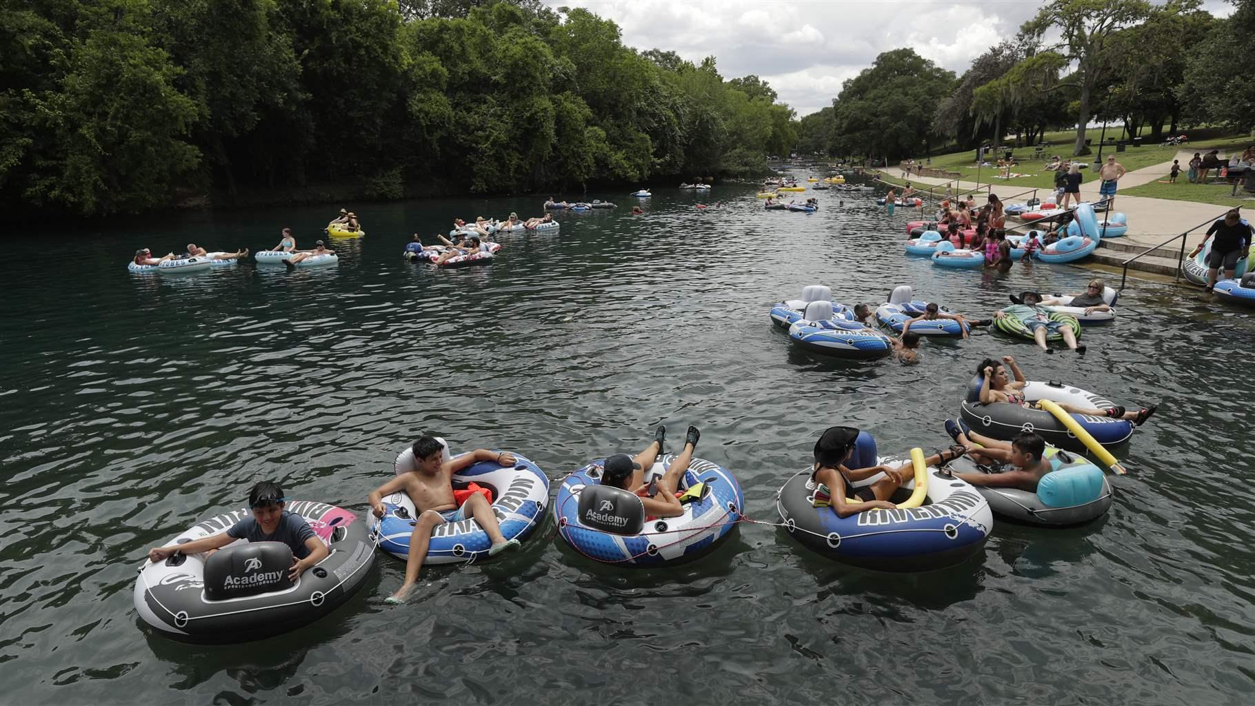 Tubers float the Comal River despite the recent spike in COVID-19 cases, Thursday, June 25, 2020, in New Braunfels, Texas. Texas Gov. Greg Abbott said Wednesday that the state is facing a "massive outbreak" in the coronavirus pandemic and that some new local restrictions may be needed to protect hospital space for new patients. 