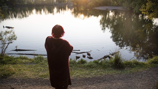 A woman who asked to remain anonymous stands outside her tent, looking over Bozeman Pond, at sunset in Bozeman, Mont., on Sept. 13, 2021. A woman who asked to remain anonymous stands outside her tent, looking over Bozeman Pond, at sunset in Bozeman, Mont., on Sept. 13, 2021.