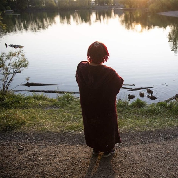 A woman who asked to remain anonymous stands outside her tent, looking over Bozeman Pond, at sunset in Bozeman, Mont., on Sept. 13, 2021. A woman who asked to remain anonymous stands outside her tent, looking over Bozeman Pond, at sunset in Bozeman, Mont., on Sept. 13, 2021.