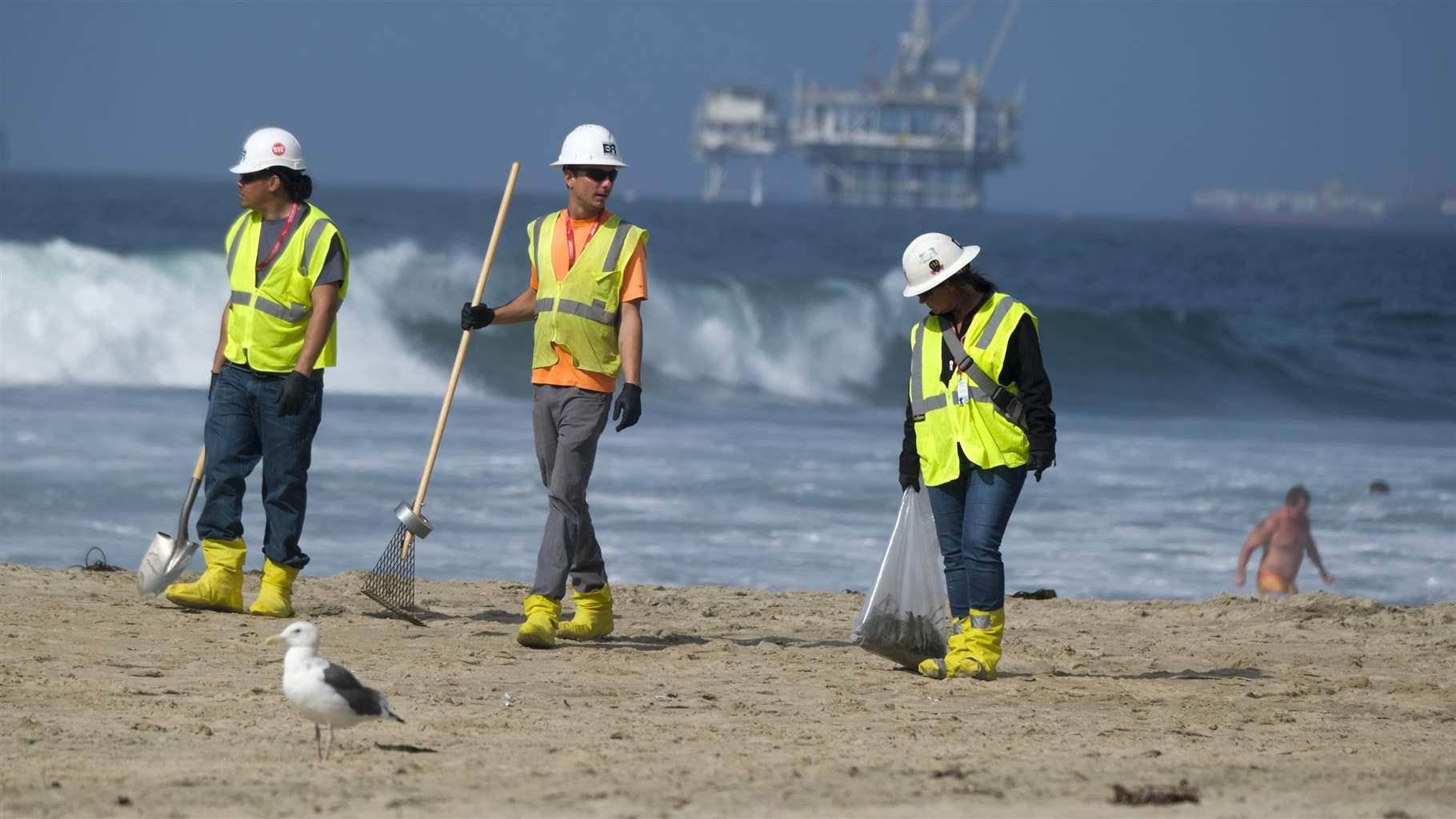 Workers in protective suits continue to clean the contaminated beach in Huntington Beach, Calif., Monday, Oct. 11, 2021. Workers in protective suits continue to clean the contaminated beach in Huntington Beach, Calif., Monday, Oct. 11, 2021.