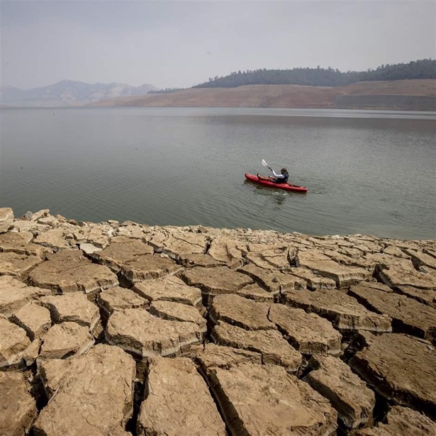 In this Aug. 22, 2021, file photo, a kayaker paddles in Lake Oroville as water levels remain low due to continuing drought conditions in Oroville, Calif. In this Aug. 22, 2021, file photo, a kayaker paddles in Lake Oroville as water levels remain low due to continuing drought conditions in Oroville, Calif.