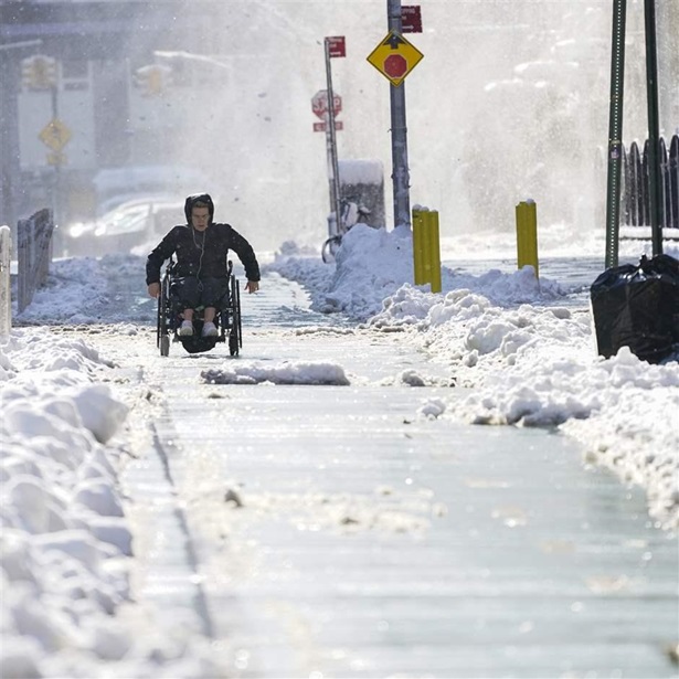 A person on a wheelchair uses the bike lane to navigate the snow covered streets in lower Manhattan, Friday, Jan. 7, 2022, in New York. A person on a wheelchair uses the bike lane to navigate the snow covered streets in lower Manhattan, Friday, Jan. 7, 2022, in New York.