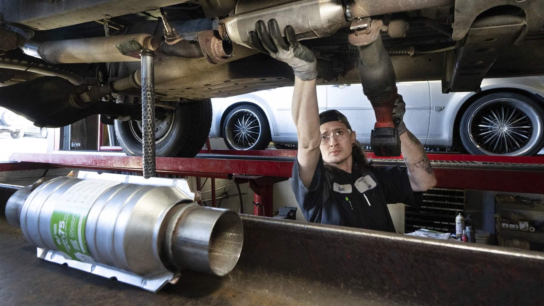 Sam Howard, assistant manager at Master Muffler in Murray replaces a worn out catalytic converter on a vehicle on Thursday, Jan. 20, 2022 in Salt Lake City. Catalytic converter thefts are spiking in Utah, and some legislation is being considered to help track stolen converters.