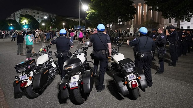 Police form a line outside the U.S. Supreme Court early Tuesday amid protesters