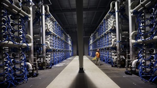 A worker passes rows of tubes used in the reverse osmosis process at the Carlsbad Desalination Project Tuesday, Sept. 22, 2015, in Carlsbad, Calif.