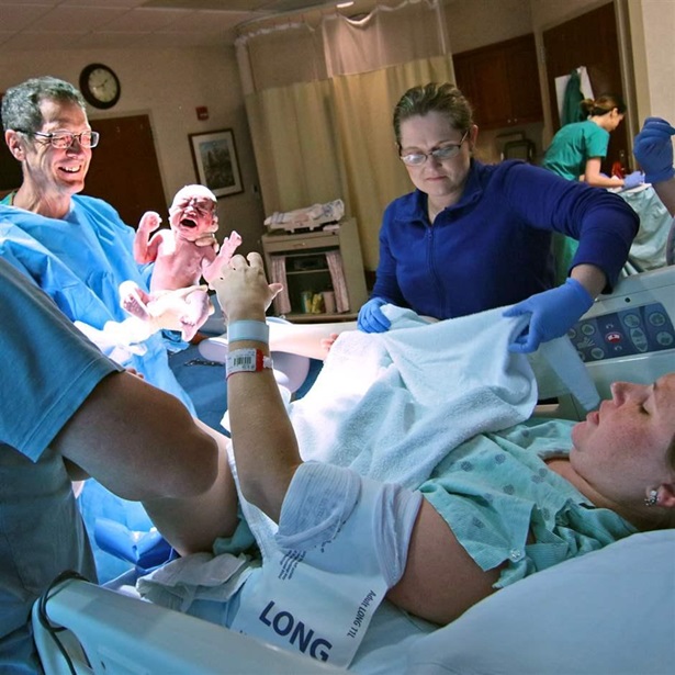 In this May 20, 2016 photo, Dr. Henry Hearn IV holds newborn Devin Hendrix Mann after delivery as Aaron Mann, left, and Amy Mann, right, look on at the AnMed Health Women and Children's Center in Anderson, S.C. Hearn is a second-generation doctor in Anderson. 