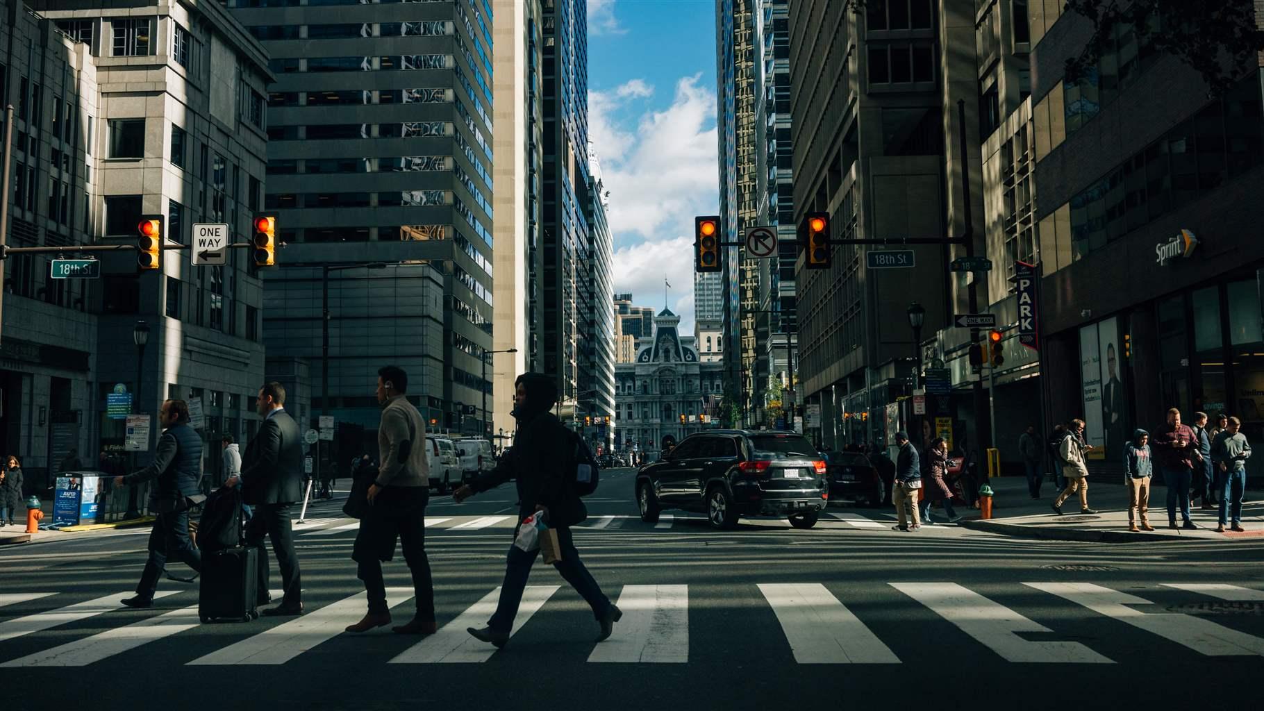 People hurrying through a busy city crosswalk.