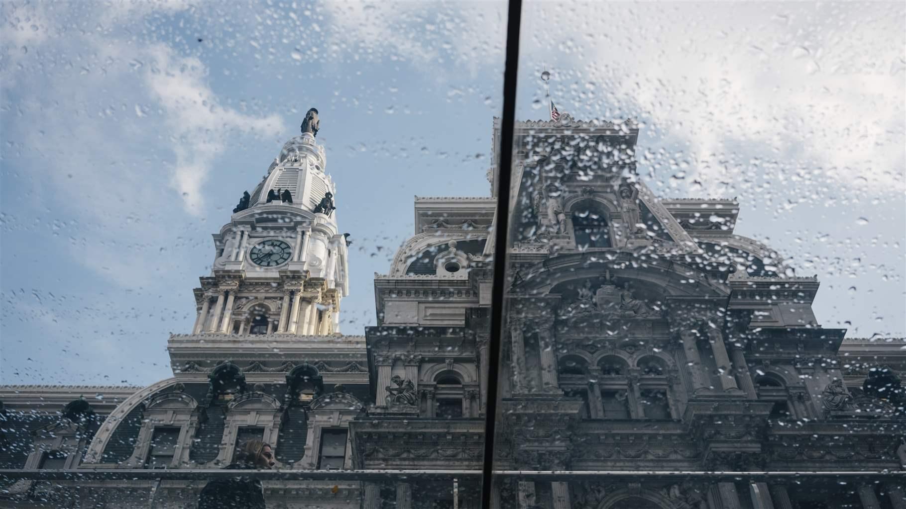 Philadelphia City Hall viewed from the glass roof of a subway entrance after the rain.