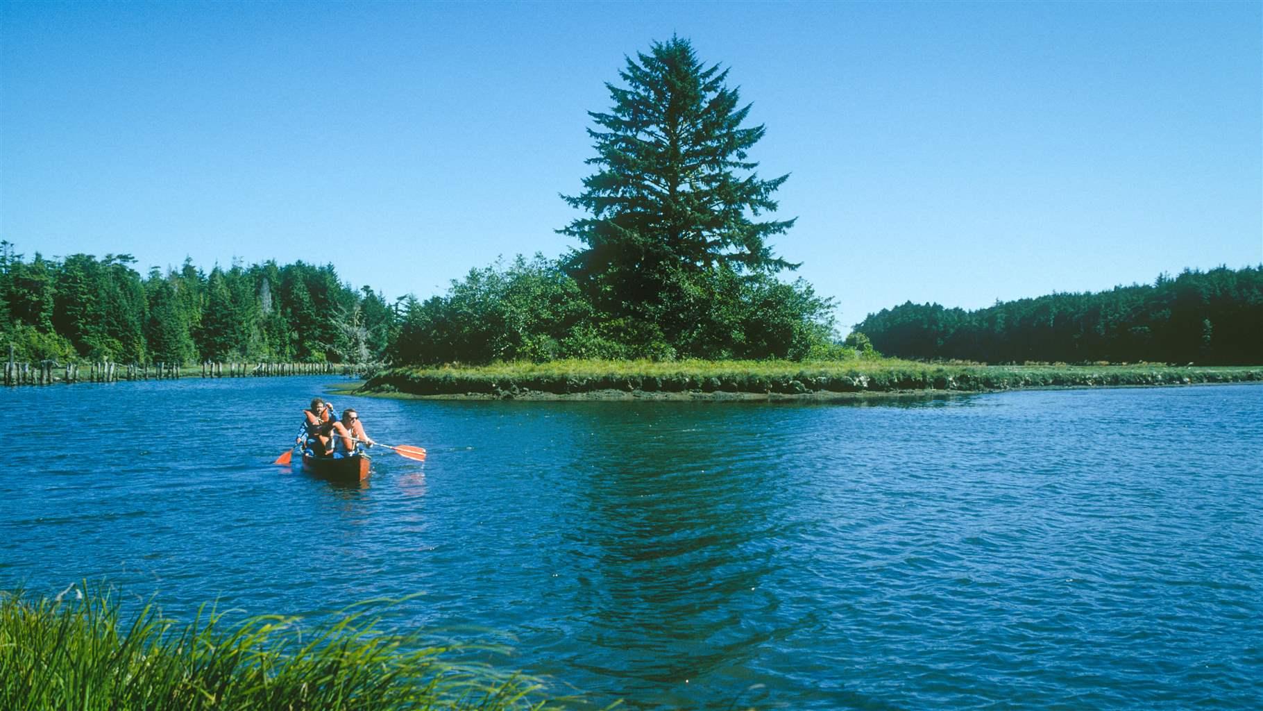 Couple birdwatching from canoe at South Slough National Estuarine Reserve, Charleston, Oregon coast.