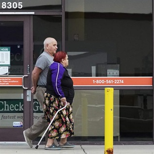 Couple walking by payday loans business