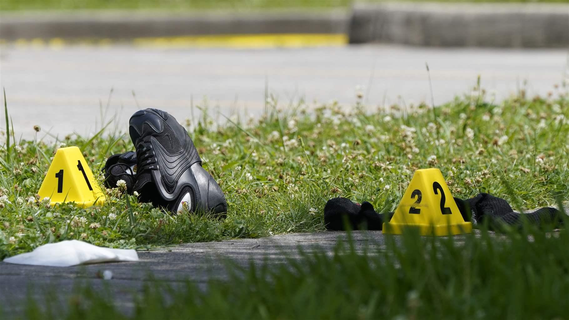 Shoes and clothing sit near evidence markers at the crime scene of a shooting at Xavier University in New Orleans, Tuesday, May 31, 2022.
