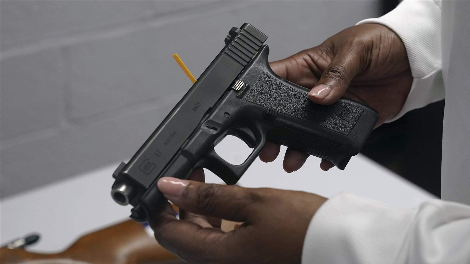 A handgun from a collection of illegal guns is reviewed during a gun buyback event in Brooklyn, N.Y., May 22, 2021.