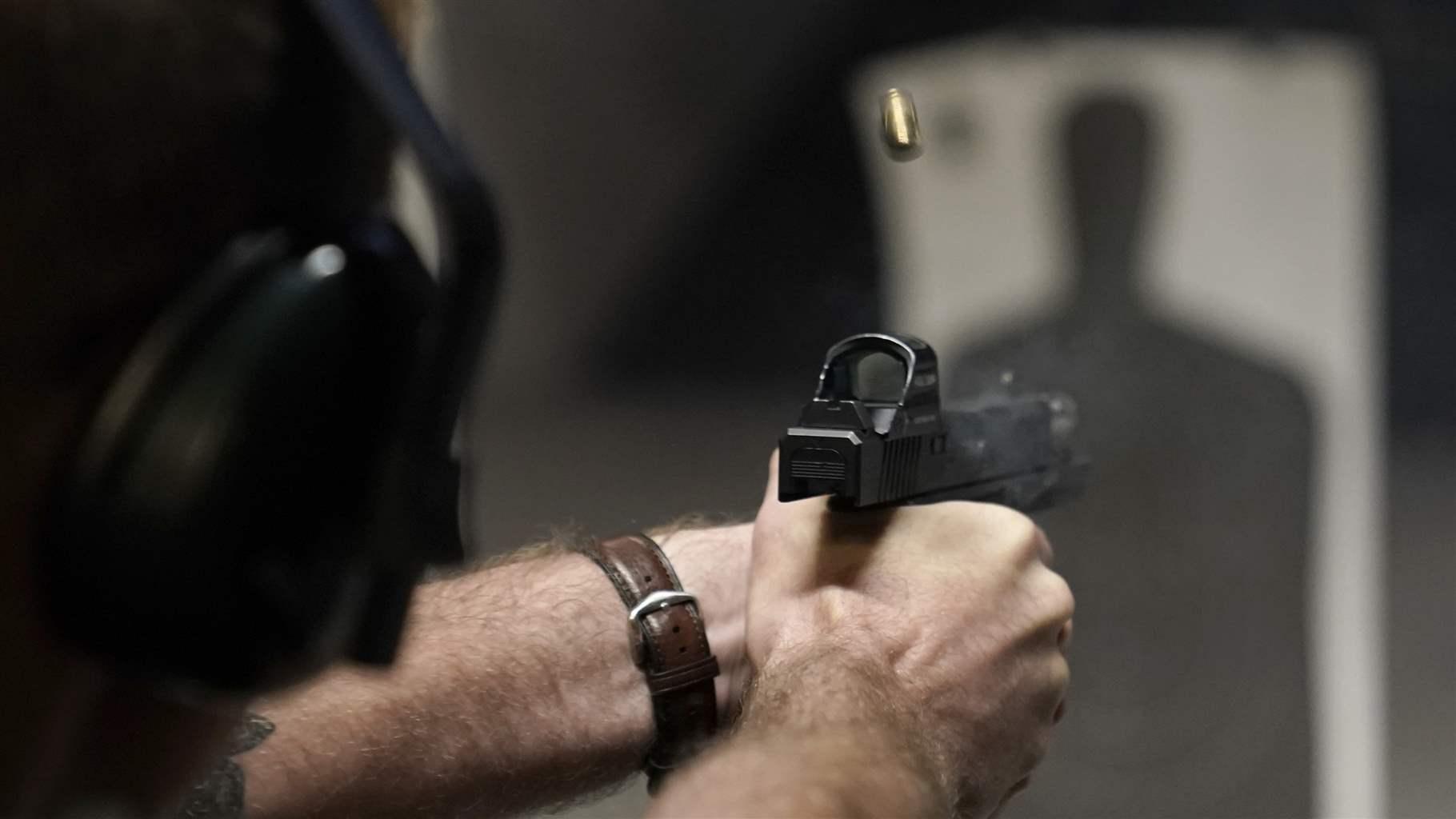 Person firing handgun at shooting range
