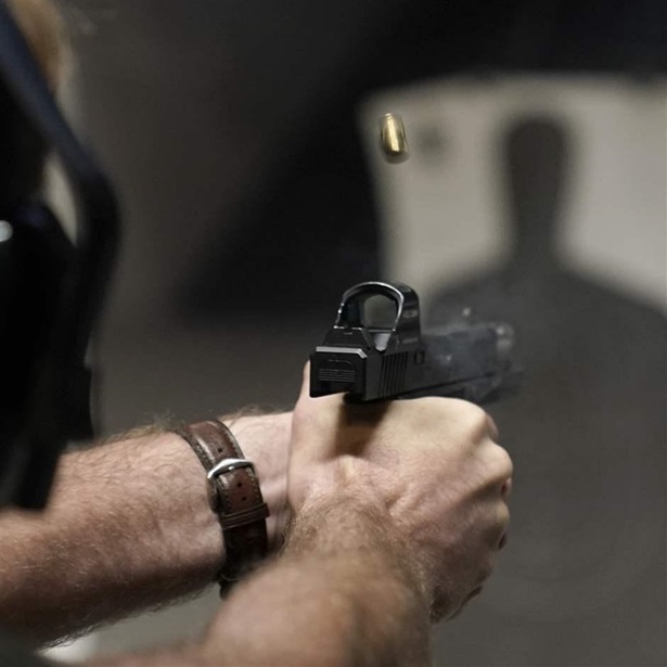 Person firing handgun at shooting range