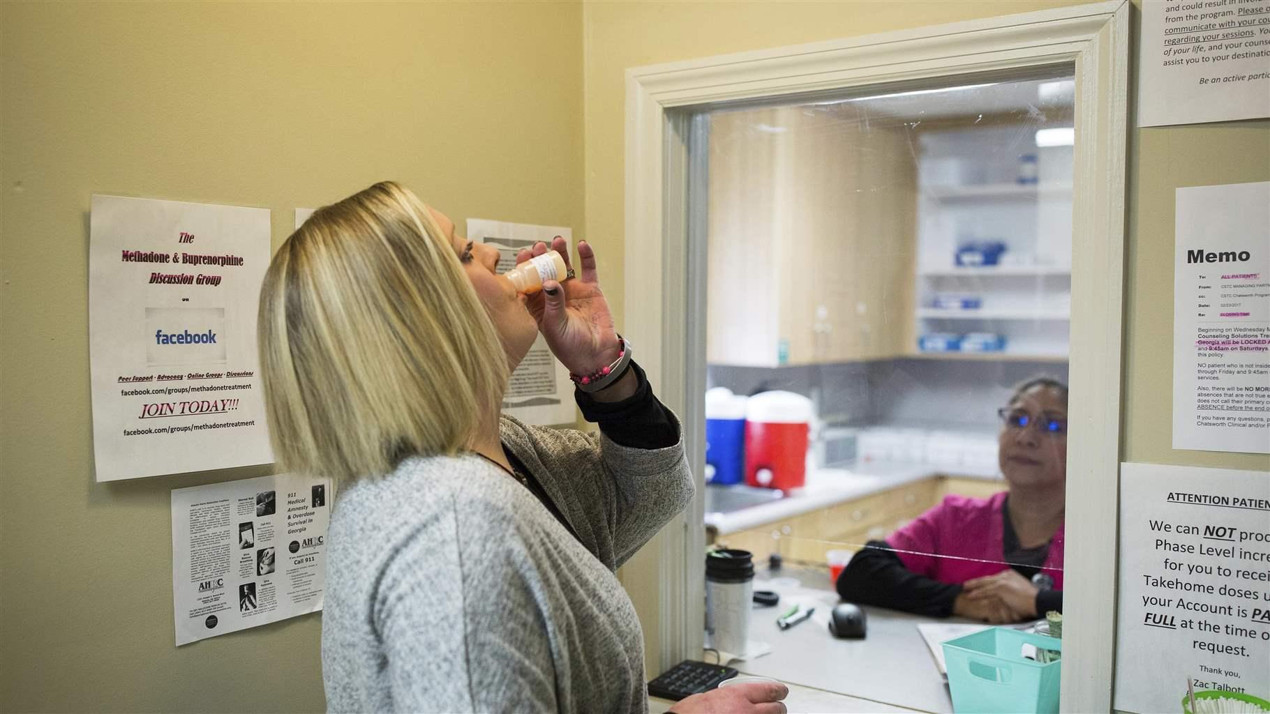 In this March 8, 2017 photo, Ashley Gardner, 34, takes a dose of methadone at Counseling Solutions of Chatsworth, Ga. Gardner, 34-year-old woman said her addiction started in the seventh grade when she wanted to numb the pain after she was sexually assaulted.