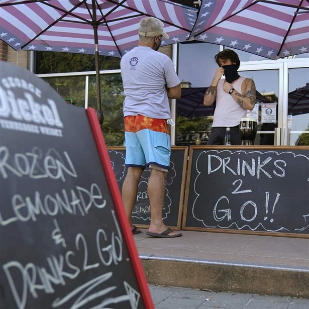 A drinks-to-go table is set up outside the Old Crow bar on Greenville Avenue in Dallas, Thursday, Aug. 13, 2020.