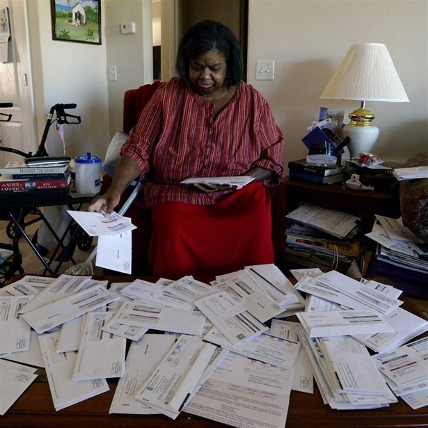 Debra Smith, 57, sorts through her medical bills in her living room on Thursday, Oct. 7, 2021, in Spring Hill, Tenn. Smith, who has health problems that prevent her from working, has about $10,000 in unpaid medical bills.