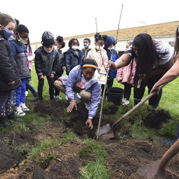 From center, family liaison coordinator LaTonia Mitchell, principal Dillondria Patterson and behavioral specialist Randi French show kindergarten students how to plant a pear tree as part of Earth Day activities in April at the Discovery Enrichment Center in Benton Harbor, Mich. From center, family liaison coordinator LaTonia Mitchell, principal Dillondria Patterson and behavioral specialist Randi French show kindergarten students how to plant a pear tree as part of Earth Day activities in April at the Discovery Enrichment Center in Benton Harbor, Mich.