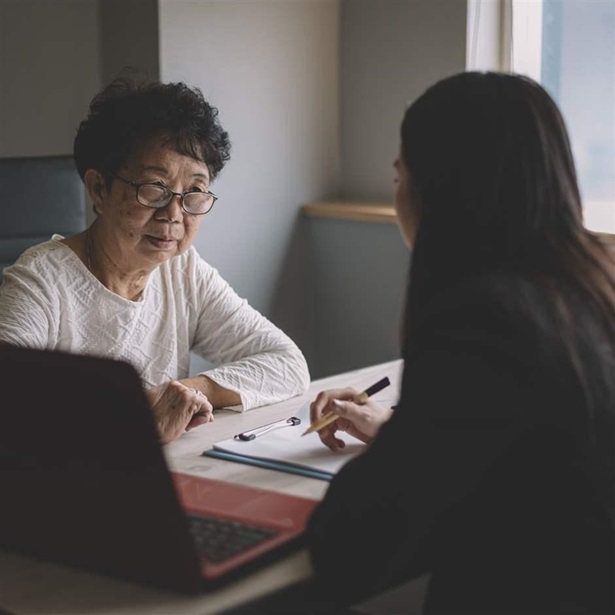 an asian chinese active senior woman having discussion with her chinese agent about her retirement investment plan